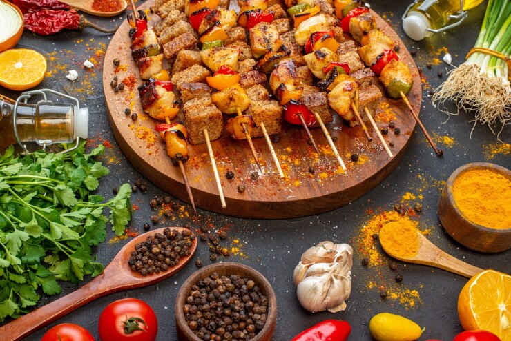 bottom-half-view-delicious-chicken-skewers-wooden-board-other-stuffs-table_140725-147650