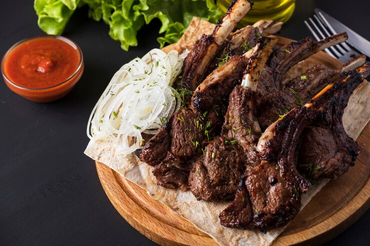 grilled-lamb-meat-wooden-board-red-sauce_151349-491