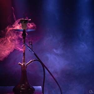The classic hookah. Beautiful background, with colored rays of light and smoke. The concept of hookah Smoking. Space for text.
